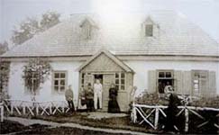 Семейство Косачей возле «серого» домика (1899 г.). Леся справа от отца, стоящего в дверях.